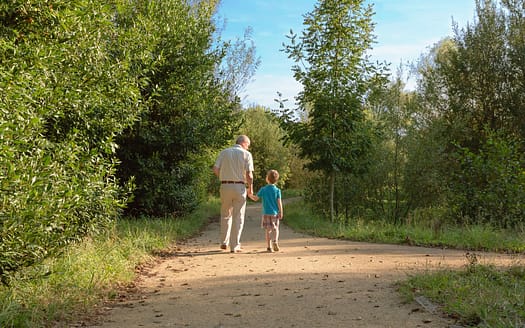 Grandfather and grandchild walking outdoors